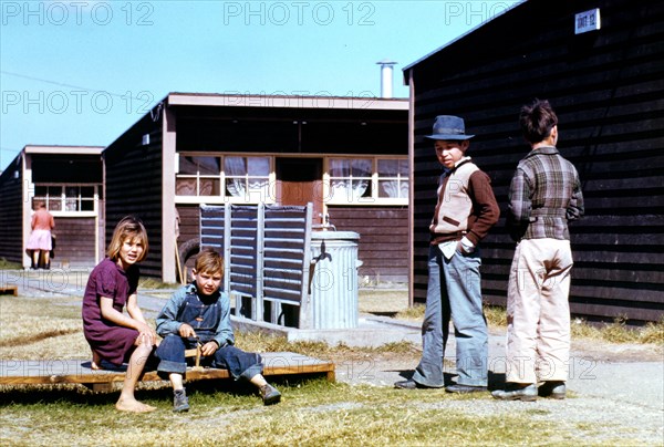 Boy building a model airplane while other children look on