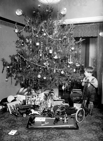 Boy on scooter in front of Christmas tree