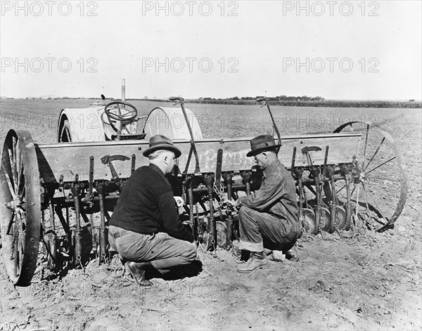 County agent inspecting farmer's wheat seeder