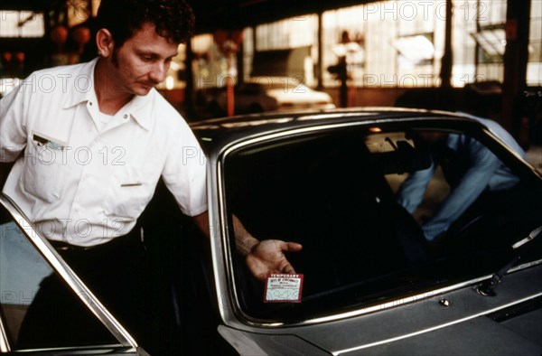 Employee places an inspection sticker on a car in Cincinnati