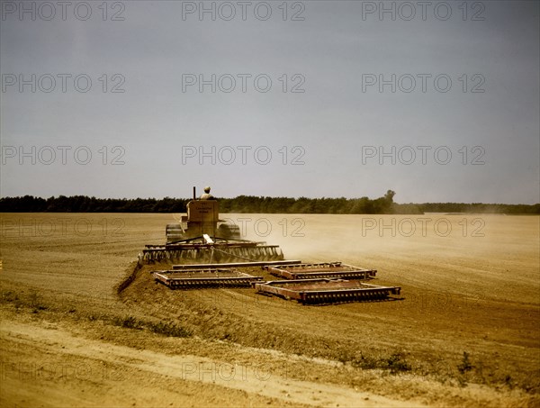 Harrowing a field with a diesel tractor