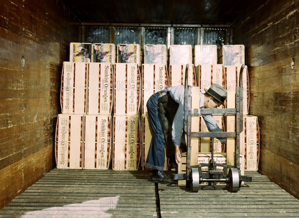 Loading oranges into a refrigerator car at a co
