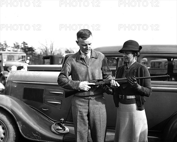 Man and woman holding shotgun