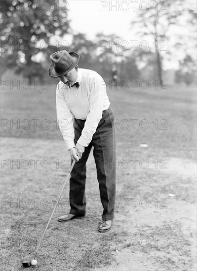 Man playing golf while smoking a cigar