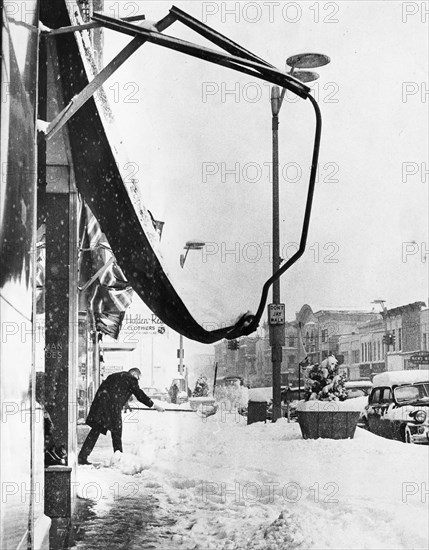 Man Shoveling Snow on City Sidewalk