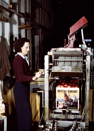 Operating a machine for putting tops on crates at a co