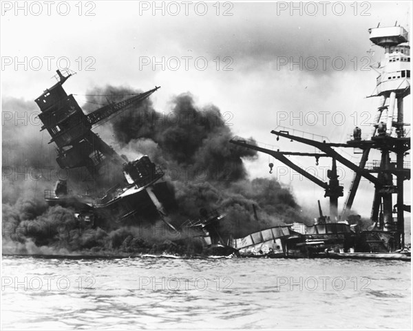 The battleship USS ARIZONA sinking after being hit by Japanese air attack on Dec. 7