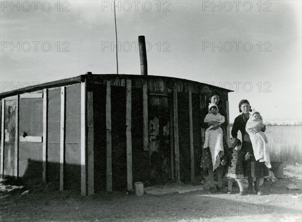 Two Women with Babies and Child in Front of Building