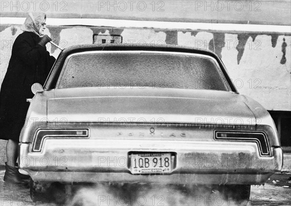 Woman Chipping Ice from Car Windshield 1969