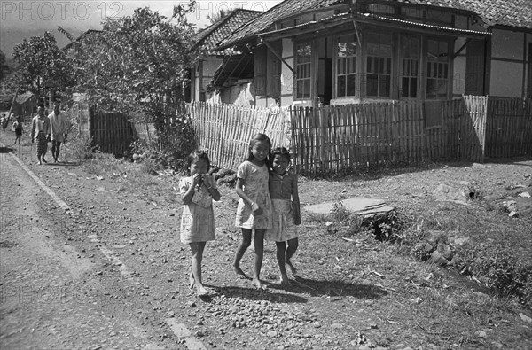 Three girls walk on the street (Gadog?); Date November 15, 1947 Location Indonesia, Dutch East Indies