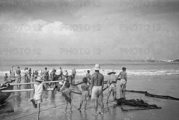 Retracting fishing nets probably in Wijnkoopsbaai (Pelabuan Ratu) Indonesia, Java, Dutch East Indies ca. 1947