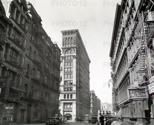 1930s New York City - Looking down Broadway, ornate Bank of Sicily Trust near center of image, sign for vegetarian restaurant, right, cars and trucks, Broadway near Broome Street, Manhattan ca. 1935