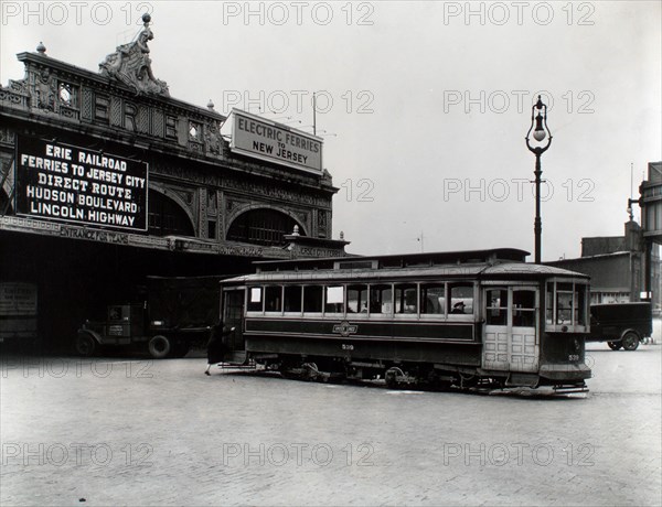 1930s New York City - Woman boards 23rd St. trolley outside Erie Railroad Ferry terminal, West 23rd St., trucks, lamp post visible.