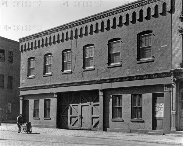 Street sweeper in front of two-story building with second story loft for rent, stable-type doors. Corlears Street, no. 3-5, Manhattan New York City ca. 1937