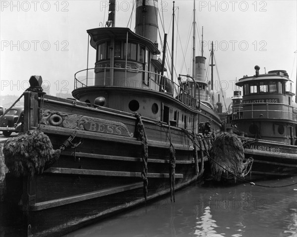 Looking along beam of tugboat Bess and at bow of McAllister Bros. tugboat, other boats in background ca. 1936