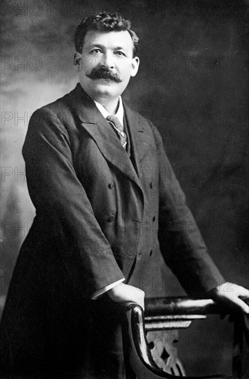 Gipsy Smith, standing next to chair, 1908