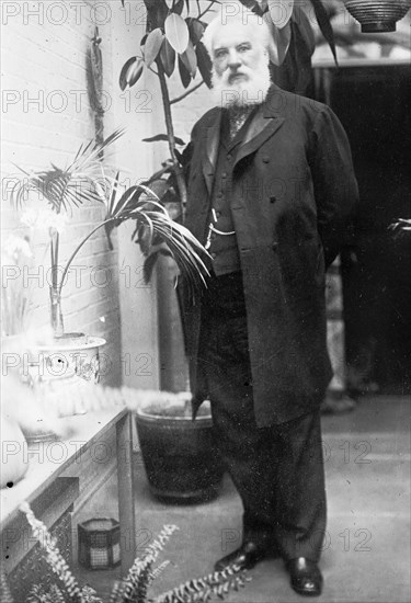 Alexander Graham Bell, standing, among plants