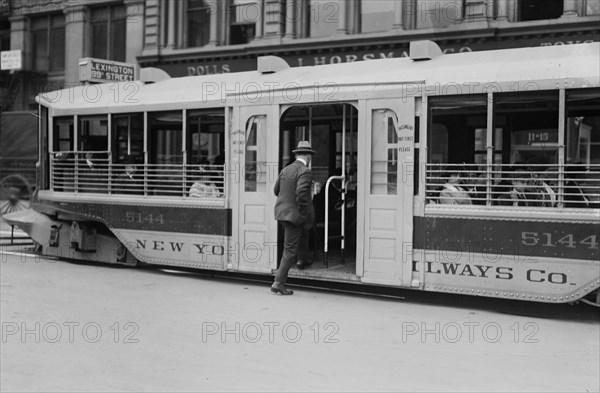 Man entering a one step trolley car in New York City ca. 1910-1915