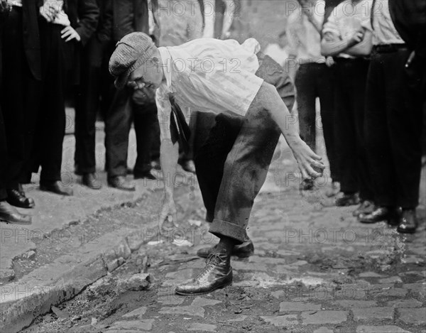 Bayonne oil workers striking, picking up stones to throw at guards ca. 1915-1916