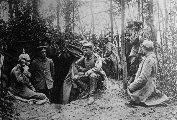 German soldiers in a dugout during World War I. One soldier is using a field telephone ca. 1914-1915