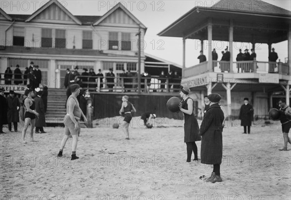 People on the beach at Coney Island throwing balls (possibly medicine balls) ca. January 1915