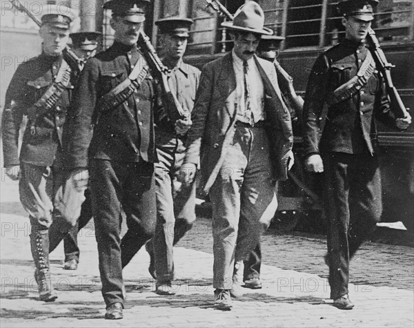 Canadian soldiers with a German man who is being arrested in Montreal, Canada, during World War I ca. 1914-1915