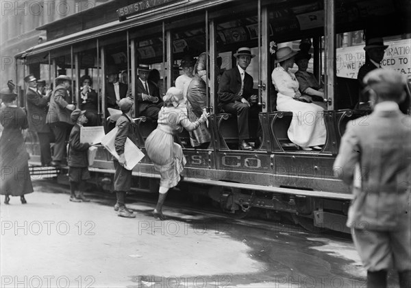 Newsies selling papers to street car riders ca. 1910-1915