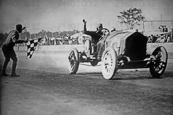 Joe Dawson crossing the finish line as the winner of the Indianapolis 500 automobile race ca. 1912
