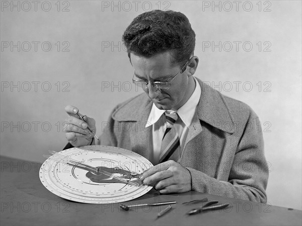 Technician at work adjusting an unidentified mechanical computing device. ca. 1949