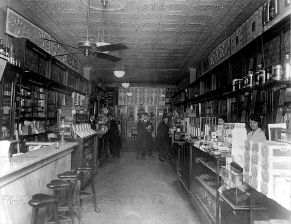 Interior of People's Drug Store, 11th and G Streets, Washington, D.C., with employees behind the counters and customers ca. 1909-1932