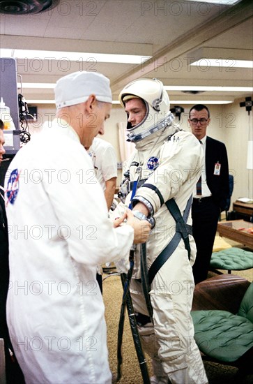 (16 March 1966) Astronaut David R. Scott, pilot of the Gemini-8 spaceflight, in the Launch Complex 16 trailer during suiting up operations for the Gemini-8 mission. NASA suit technician Joe Schmitt helps the astronaut put on his gloves.