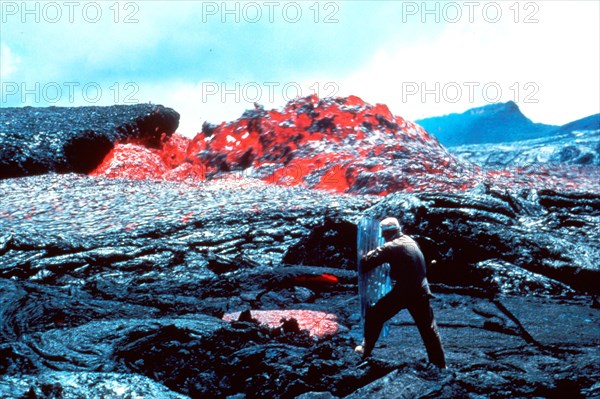 Taken on March 31, 1984, in Hawaii Volcanoes National Park, we see Ed Wolfe taking a temperature measurement on a sluggish channel eddy on Mt. Kilauea which had begun erupting in 1983.