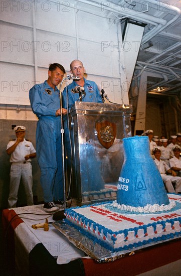 (16 Dec. 1965) Astronauts Walter M. Schirra Jr. (left), command pilot, and Thomas P. Stafford, pilot, speak to crewmen onboard the aircraft carrier USS Wasp after successful recovery of the Gemini-6 spacecraft.