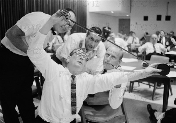 (23 Sept. 1966) Astronauts Charles Conrad Jr. (with pipe) and Richard F. Gordon Jr. (background) view negatives from their Gemini-11 mission.