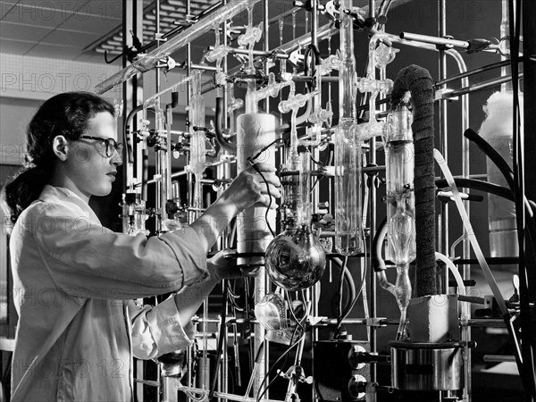 A materials researcher at the NACA’s Lewis Flight Propulsion Laboratory examines a surface crack detection apparatus in the Materials and Stresses Building during December 1952.