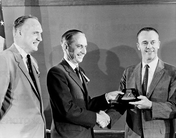 (1 Oct. 1961) Astronaut Alan B. Shepard Jr. (right) receives a plaque and award from members of the British Rocket Society.
