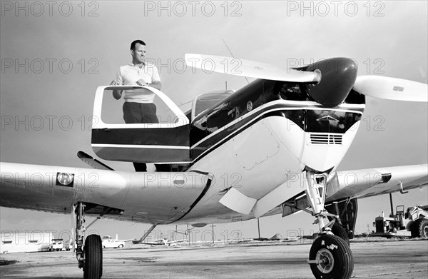 (1963) Astronaut L. Gordon Cooper Jr., prime pilot for the Mercury Atlas 9 (MA-9) 22-orbit flight, stands by his privately owned Beechcraft Bonanza aircraft, at Patrick Air Base, Florida.