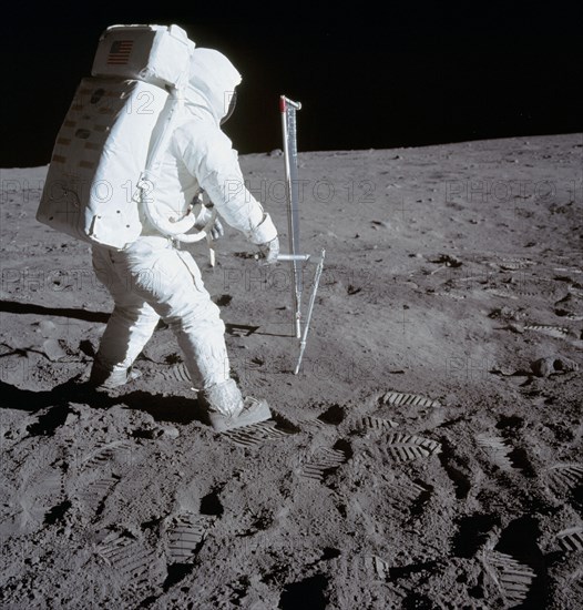 (20 July 1969) Astronaut Edwin E. Aldrin Jr., lunar module pilot, is photographed during the Apollo 11 extravehicular activity (EVA) on the moon. He is driving one of two core tubes into the lunar soil.