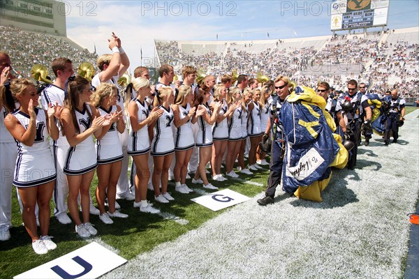 2006 - Brigham Young University cheerleaders greet members of the U.S. Navy Parachute Demonstration Team "Leap Frogs" after they parachuted into the Lavell Edwards Stadium, Provo, Utah, prior to a football game on Sept. 9, 2006.