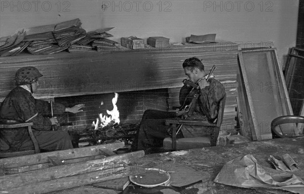 Warsaw Uprising: Wieslaw Chrzanowski "Wieslaw" (with MP40 submachine gun) and Jerzy Sikorski "Sixton" (on the left) from "Anna" company of batallion "Gustaw" in house on Jasna 19 Street after surrender ca. 1944