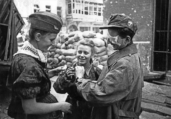 Warsaw Uprising: Two medics and a soldier (right) from "Parasol" battalion after coming out of sewers at Warecka Street near Nowy Swiat (North Sródmiescie district). In the center Maria Stypulkowska-Chojecka "Kama". On the right Krzysztof Palester "K
