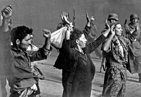 Stroop Report - Warsaw Ghetto Uprising,  Picture taken at Nowolipie street looking East, near intersection with Smocza street, Woman on the right: Hasia Szylgold-Szpiro ca. 1943