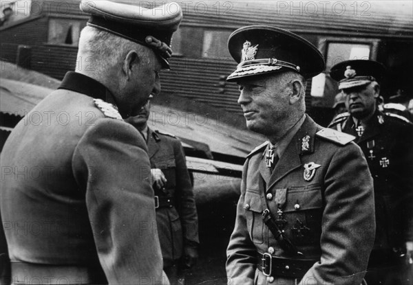 Marshal Erich von Manstein, German commander of the Wehrmacht, Nazi Germany's armed forces during the Second World War (left) welcomes Marshal Ion Antonescu to the field airfield. In the background, a visible fragment of the Junkers Ju-52 transport aircra