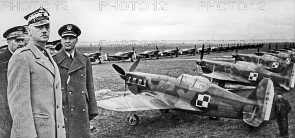 General Wladyslaw Sikorski's visit to the Polish Air Force training center in Bron - preparation for the parade. From the right: General Józef Zajac, General, Wladyslaw Sikorski, General Victor Denain. Morane Saulnier MS 406 fighter aircraft are als