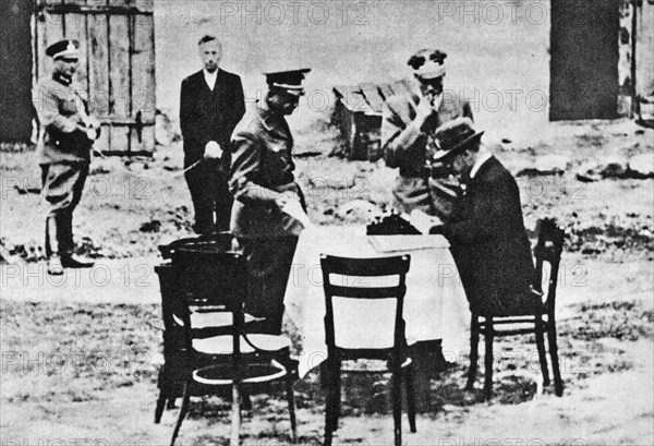 German-occupied city Bydgoszcz in Poland. Open air session of the Nazi-German “Special court in Bydgoszcz” (de: Sondergericht Bromberg). Polish defendant is visible in the background (second from the left). The person sitting at the table (in hat) is