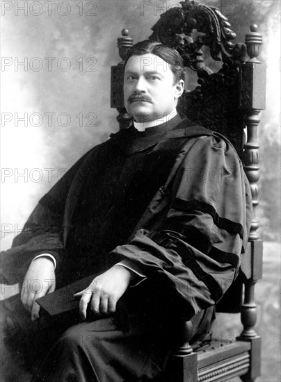 Charles Burch seated in academic robe