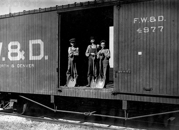 Three young boys with shovels standing in doorway of a Fort Worth & Denver train car, 1912