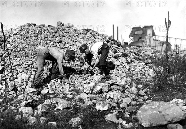Two young boys collecting rocks, 1912