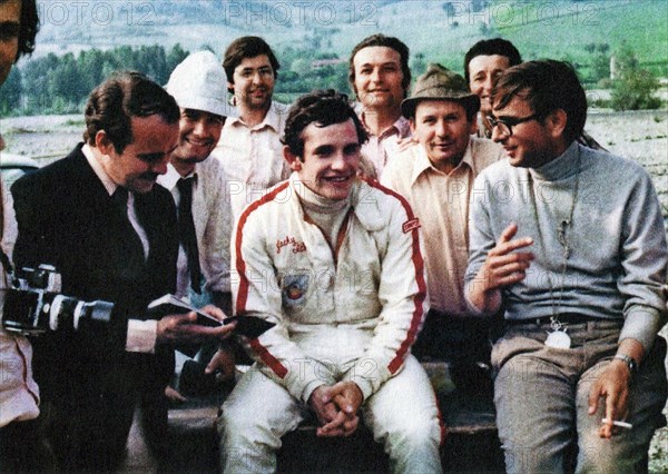Belgian car driver Jacky Ickx (in the center), and the Italian engineer and builder Gian Paolo Dallara (on the right), in a conversation on the Varano de 'Melegari circuit ca. late 1960s or early 1970s