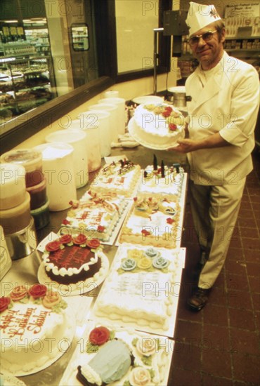 German Immigrant Hans Strzyso Is the Chief Baker at Madsens Supermarket. He Specializes in All Types of Decorated Cakes and Ethnic German Baked Goods Which Are Made Fresh Daily ca. 1975